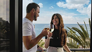 Couple enjoying a drink on the balcony with sea view during a relaxing F1 Imola weekend experience