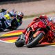 MotoGP riders cornering at high speed on race track