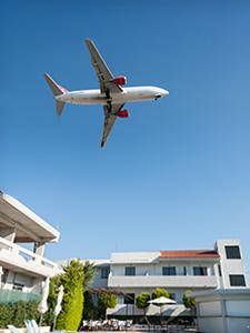 Avión de pasajeros despegando sobre tejados – organizado para viajes en grupo.