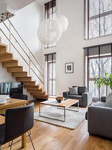 Helles und modernes Duplex-Apartment mit stilvoller Einrichtung und großen Fenstern.