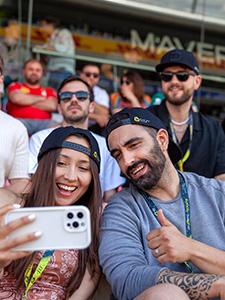 Fans machen ein Selfie und genießen die Stimmung von der Tribüne aus.