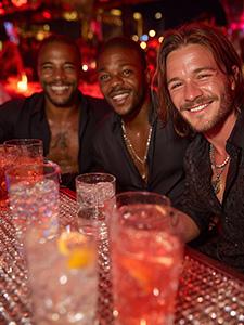 Jubelnde Zuschauer an einer vollen Rennstrecke unter blauem Himmel.