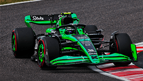 Green Stake F1 car cornering on track during a race