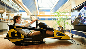 A man using a F1 racing simulator branded with Global-Tickets